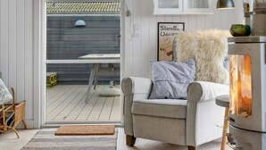 A modern living room with a sofa, a fireplace, and a view of the outdoor deck. - "Akseline" - 20m from the sea by Interhome (Assens)