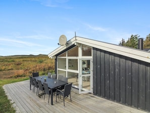 A modern house with a deck, a satellite dish, and a view of the landscape.