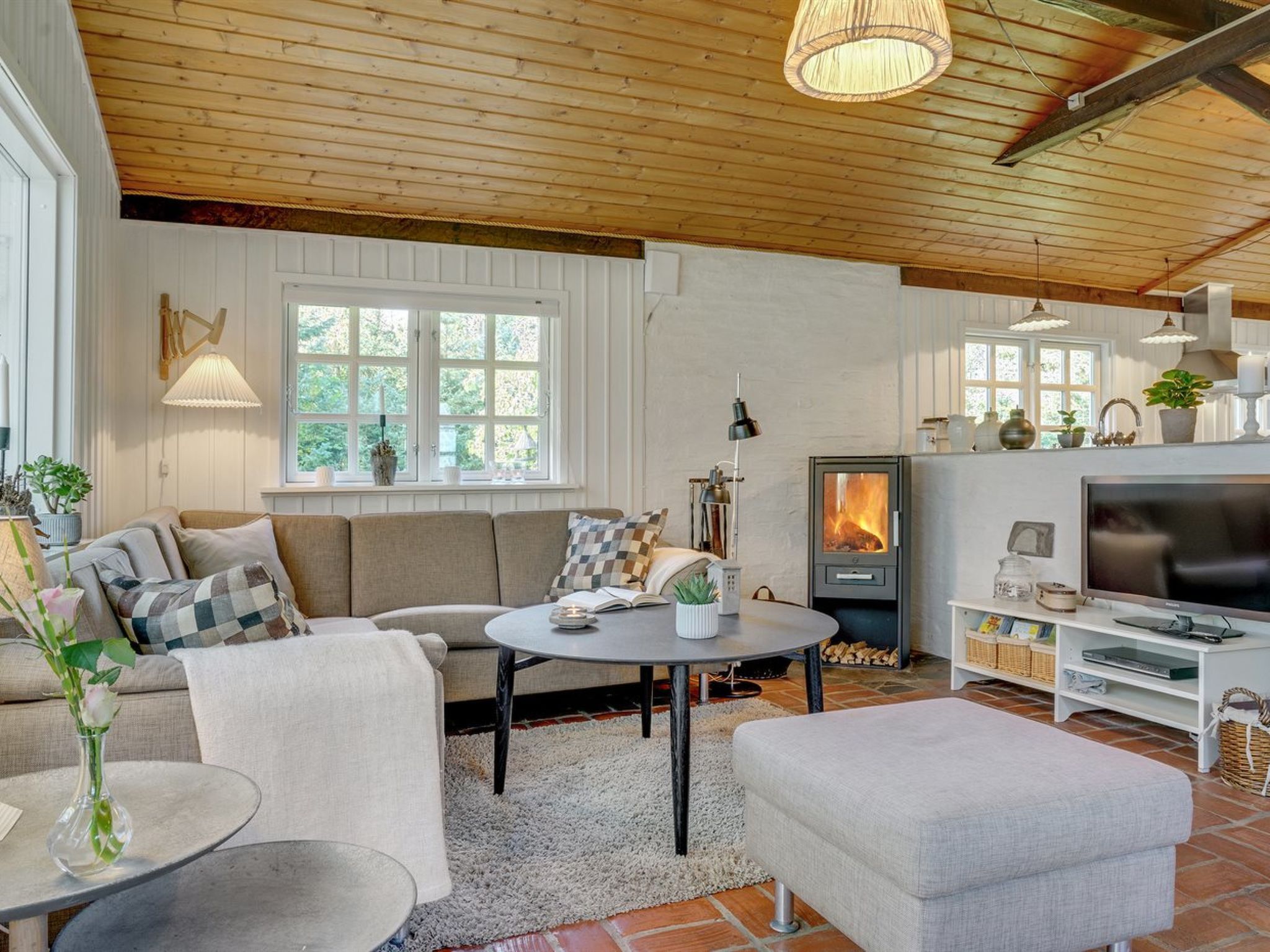 A cozy living room with a fireplace, a sofa, a coffee table, and a TV.