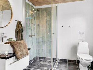 A modern bathroom with a glass shower enclosure, a white toilet, and a sink with a towel rack. - "Sigfred" - 1.5km from the sea by Interhome (Hals)