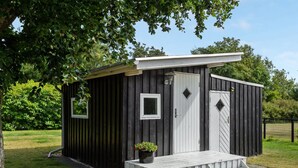A small wooden cabin with a porch, a door, and a window. - "Sigfred" - 1.5km from the sea by Interhome (Hals)