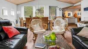 A spacious living area with a high ceiling, wooden beams, a dining table with chairs, a kitchen area, and large windows. - "Sigfred" - 1.5km from the sea by Interhome (Hals)