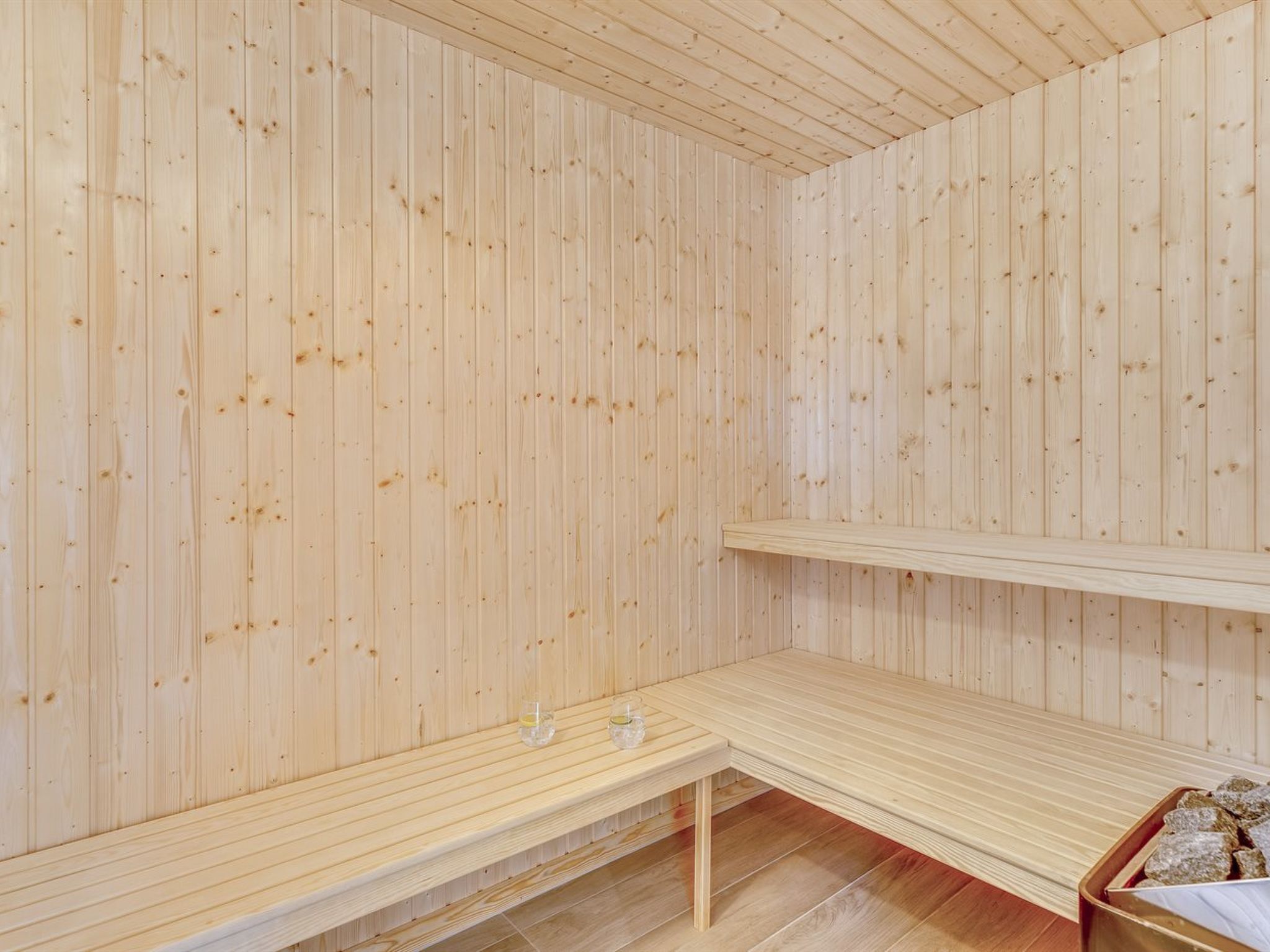 Et sauna-rum med trævægge og bænke.
