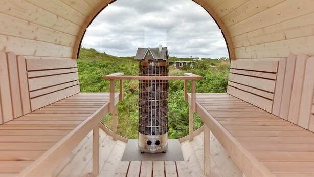 Une structure en bois dotée d’une ouverture circulaire, de bancs et d’un foyer central.