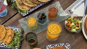 A table set with various dishes including flatbreads, salads, and a bowl of soup. - Riad Moulay Driss et GiacomoOpens  (Fes)