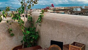 A table with pastries and a cup of tea, overlooking a cityscape. - Riad Moulay Driss et GiacomoOpens  (Fes)