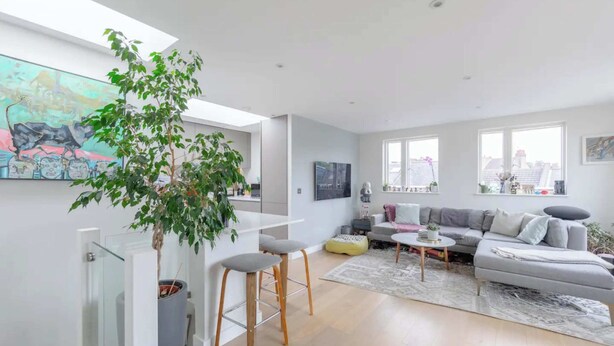 Een moderne woonkamer met een grijze bank, een salontafel en een groot raam.