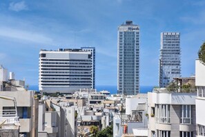 A cityscape with modern high-rise buildings and a view of the sea.