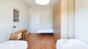 Une chambre avec un lit, un bureau, une chaise et une armoire.