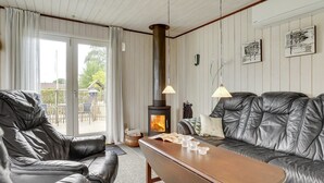 Un salon chaleureux avec une cheminée, des canapés en cuir et une table basse en bois.