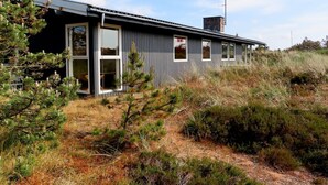 A modern house with a grey exterior, large windows, and a chimney. - "Elsa" - 700m from the sea by Interhome (Oksbøl)