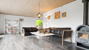 Una sala de estar moderna con chimenea, un sofá, una mesa de centro y una estantería.