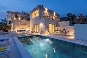 A modern two-story house with a swimming pool, outdoor seating, and a balcony with a table and chairs. - Modern Villa Callista - 3 bedroom luxury villa (Žrnovnica)
