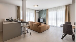 A modern living room with a sofa, a dining area, and a kitchen island. - Modern Villa Callista - 3 bedroom luxury villa (Žrnovnica)