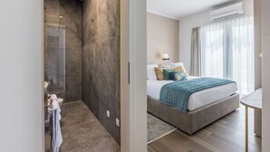 A modern hotel room with a large bed, a bathroom with a shower, and a view of the outdoors. - Modern Villa Callista - 3 bedroom luxury villa (Žrnovnica)