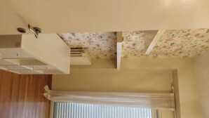 A room with a wooden floor, a white ceiling with a vent, and a window with blinds. - Modern and spacious apartment between sea and mountain (Val Vomano)