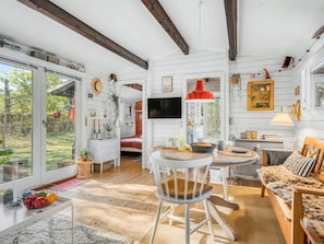 A spacious room with a large window, a dining area, and a cozy seating area.