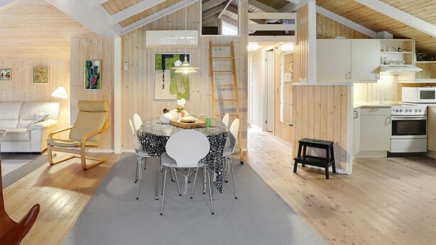 A modern loft-style room with a dining area, kitchen, and living space.