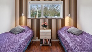 A bedroom with two beds, a window, and a bedside table with books. - "Andrea" - 1.4km from the sea by Interhome (Hals)