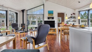 A modern kitchen with a large island, wooden flooring, and large windows offering views of the outdoors. - "Andrea" - 1.4km from the sea by Interhome (Hals)