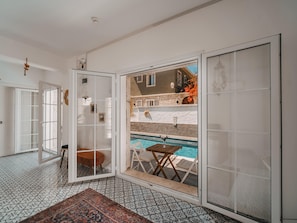A spacious room with a large sliding glass door leading to an outdoor area with a pool. - Mea Reisdere (Cesme)