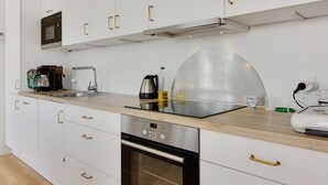 Una cocina moderna con armarios blancos, electrodomésticos de acero inoxidable y encimera de madera.