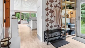 Une cuisine moderne avec des armoires blanches, un plafond en bois et une vue sur l’extérieur.