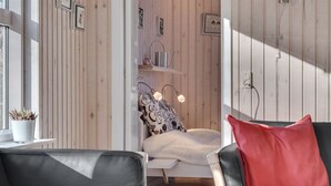 Ein modernes Wohnzimmer mit einem Bett, zwei Ledersofas und einem roten Kissen.