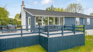 Un bâtiment moderne doté d’un toit plat, de grandes fenêtres et d’une terrasse.