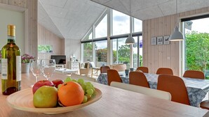 Ein moderner Essbereich mit Holztisch, Obstschale und Weinflasche.