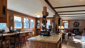 Eine gemütliche Küche mit Holzelementen, einer großen Kochinsel und einem Kamin.