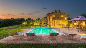 A swimming pool with lounge chairs, a stone building, and a covered patio area. - Villa Flaminia 8+2 - Emma Villas (Gualdo Cattaneo)