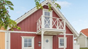 Un bâtiment rouge avec un balcon blanc et une porte portant le numéro 205.