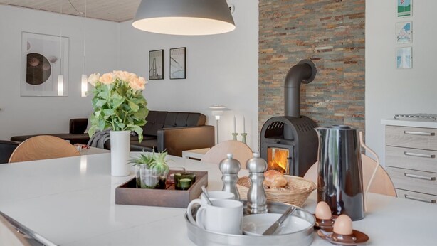 Una cocina moderna con una isla central, una pared de ladrillo y una estufa de leña.