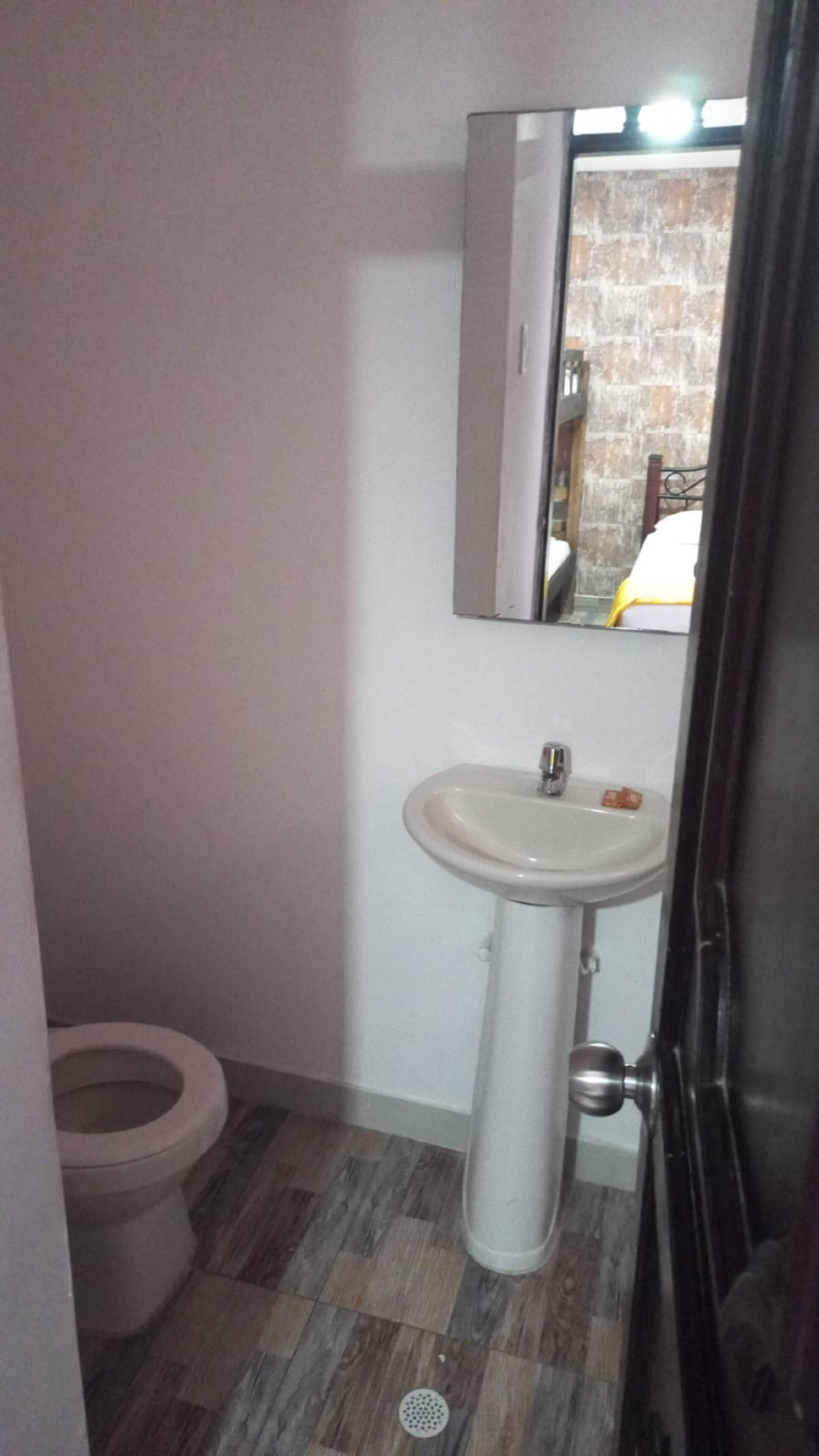 Un bagno con il water, un lavandino e uno specchio.