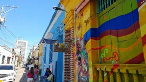 A colorful street with a sign for 'El Buffet de la Plaza'. - Apartment 1cl2 in the Walled Center With Aircon (Cartagena)