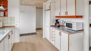 A modern kitchen with white cabinets, a microwave, and a coffee maker. - "Terhi" - 200m from the sea by Interhome (Fanø)