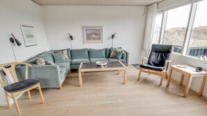 A modern living room with a green sofa, a black leather chair, a wooden coffee table, and a small table with a bowl. - "Terhi" - 200m from the sea by Interhome (Fanø)