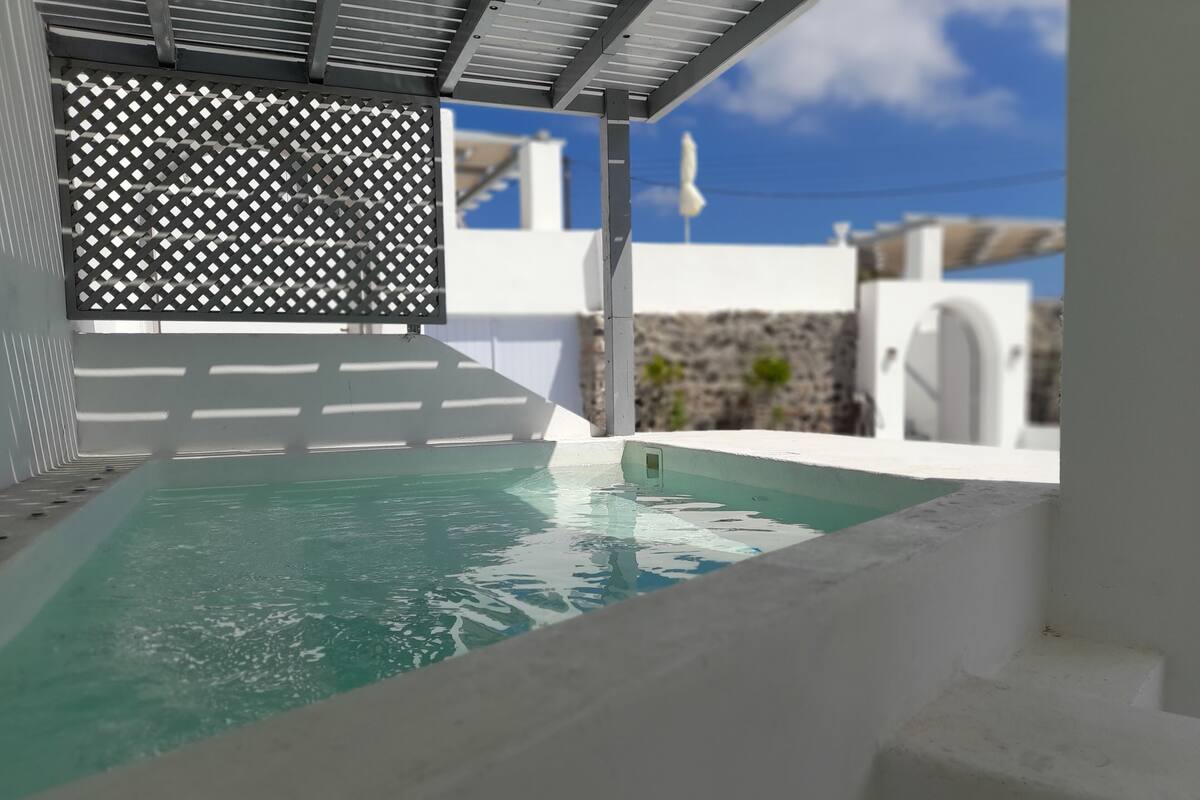 A swimming pool with a white deck and a metal lattice structure.