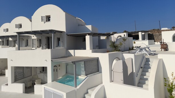 A modern white building with a swimming pool, outdoor seating, and a staircase leading to an upper level. - atlantis villa - sea paradise (Santorini)