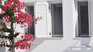A white building with two windows, one with shutters open and another closed. - atlantis villa - sea paradise (Santorini)