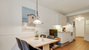Een eethoek met een tafel, stoelen en een keuken op de achtergrond.