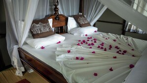 A bed with white linens, a wooden headboard, and decorative pillows.