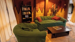 A cozy room with a green checkered sofa set, a bookshelf, and a wooden coffee table.