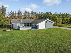 A two-story house with a covered patio, a garage, and a swing set in the yard.