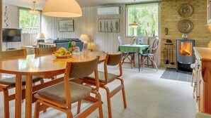 Ein gemütlicher Essbereich mit einem runden Tisch, Holzstühlen und einer hängenden Leuchte.