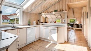 A modern kitchen with a large island, wooden ceiling, and ample natural light from skylights. - "Skev" - 200m to the fjord by Interhome (Hvide Sande)