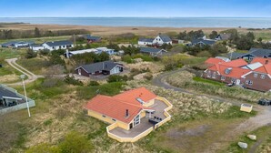An aerial view of a coastal residential area with houses, a beach, and a clear sky. - "Skev" - 200m to the fjord by Interhome (Hvide Sande)