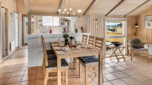 A wooden interior with a dining area, kitchen, and a view through a window. - "Skev" - 200m to the fjord by Interhome (Hvide Sande)