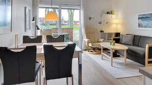 A modern living room with a dining area, a sofa, and a coffee table.